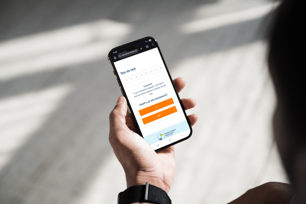 Hand die telefoon vasthoudt met daarop de testamenttest