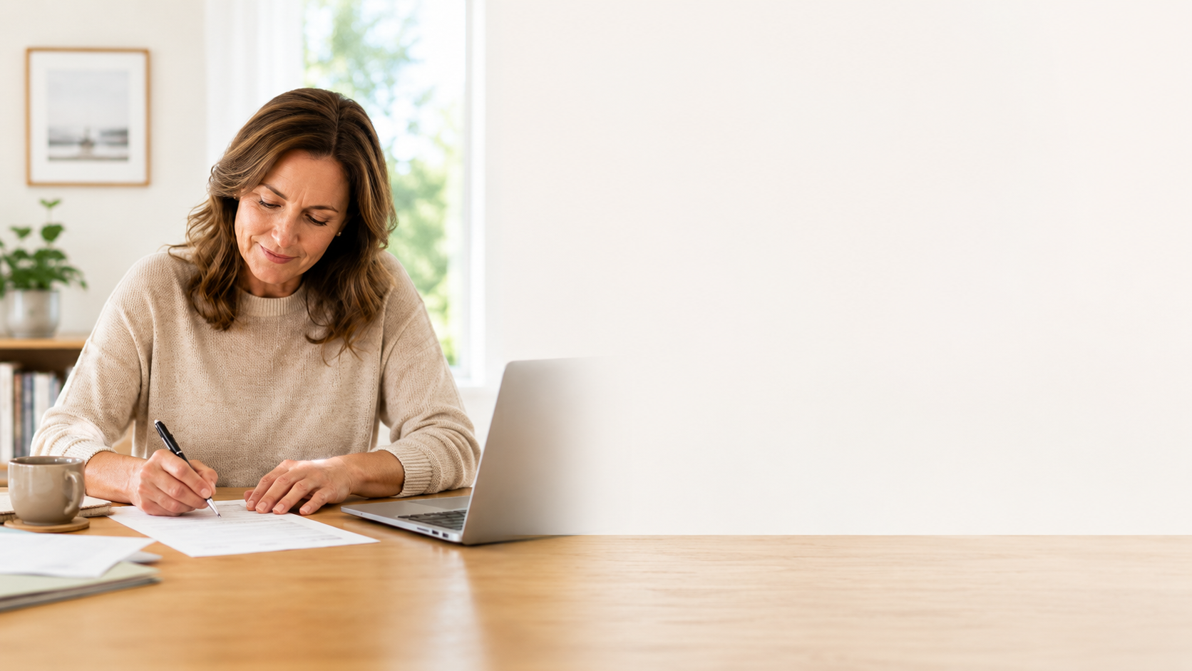 Vrouw vult aan een tafel een formulier in voor periodiek schenken, met laptop en documenten naast zich.