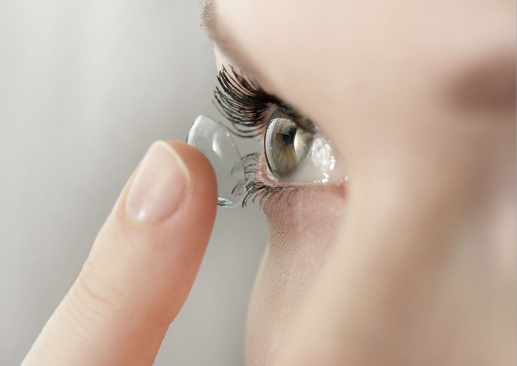 Een dame doet haar contactlens in.
