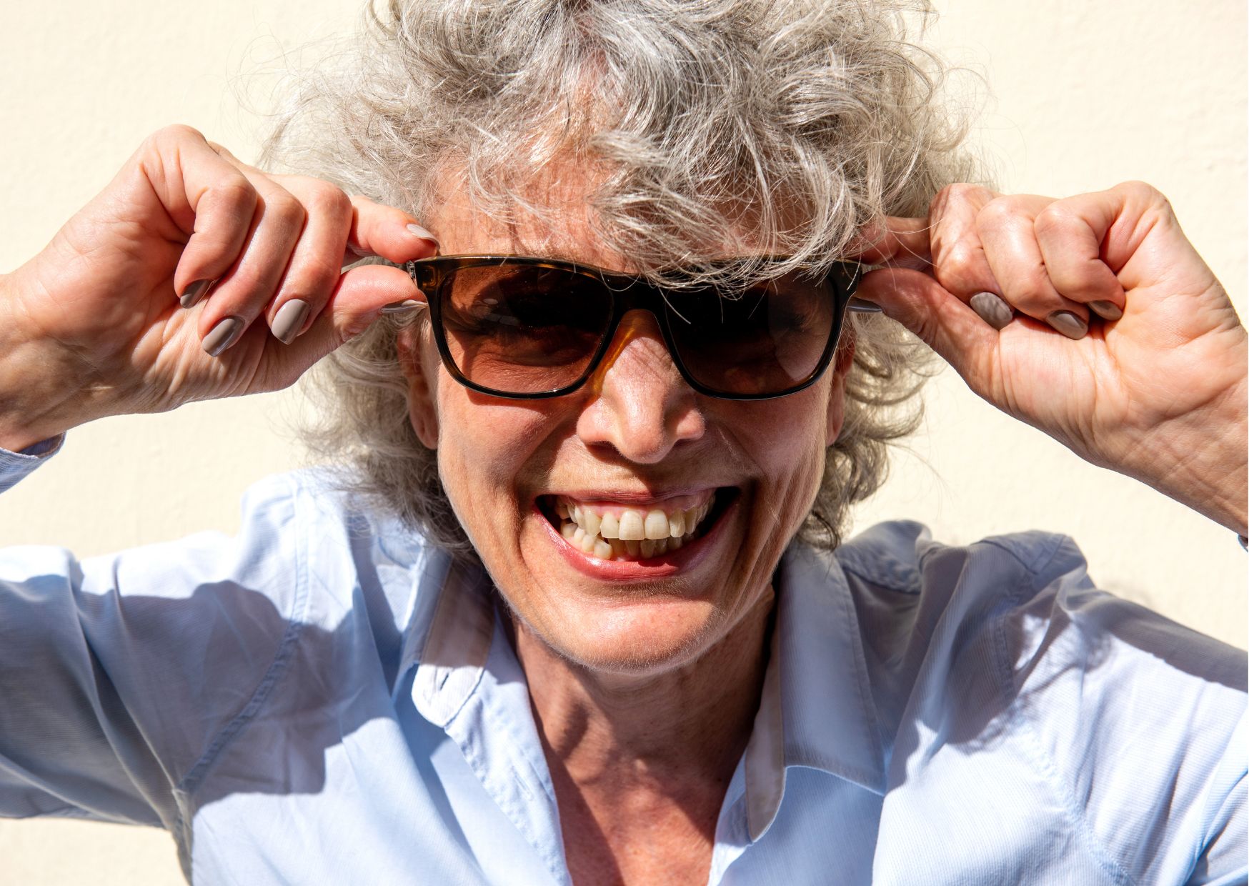 Een dame zet haar zonnebril op.