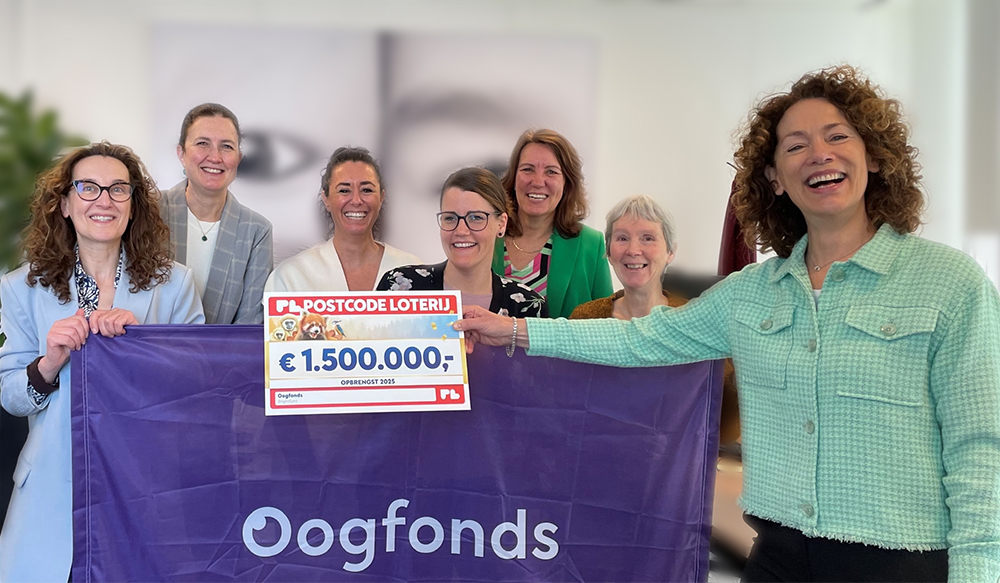 Medewerkers van Oogfonds met cheque postcodeloterij in handen